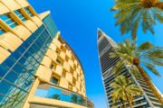 Riyadh , Saudi Arabia - Jannuary 8, 2025: Palm trees framing the modern architecture of Al Faisaliah Tower and Kingdom Centre under a deep blue sky in Riyadh